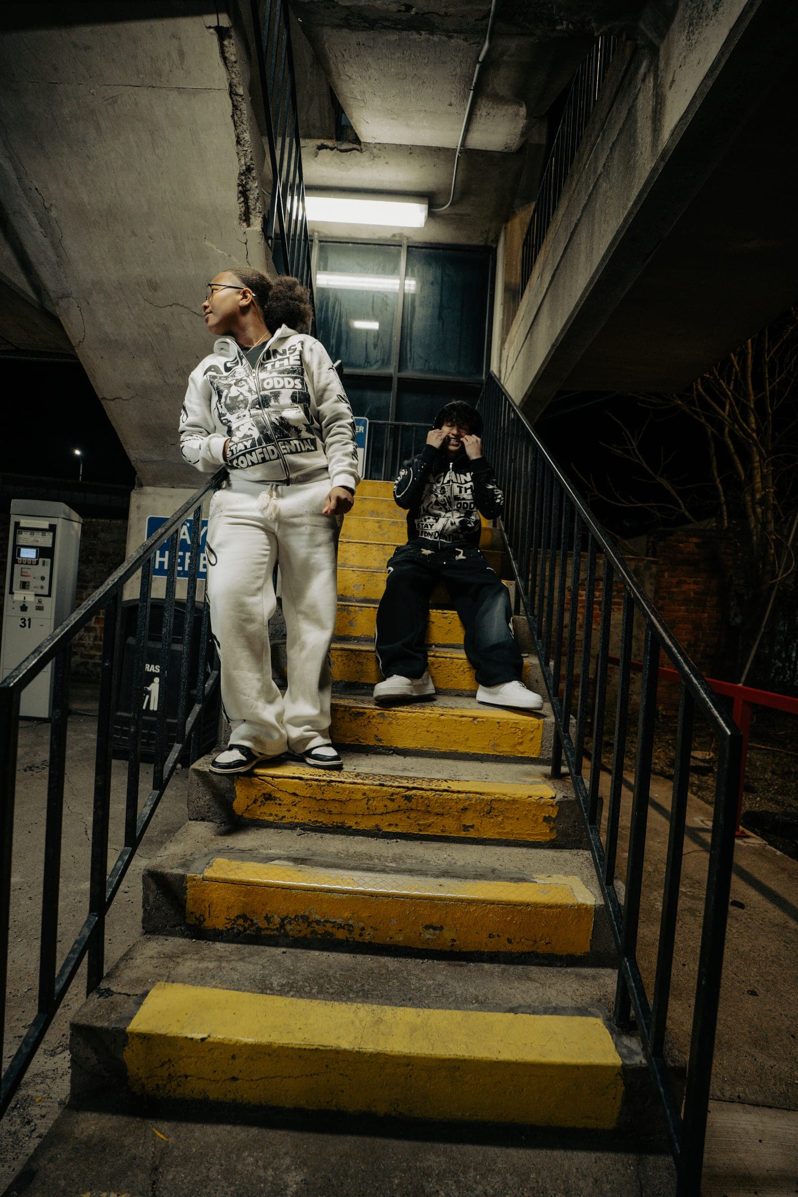 Two men on a yellow-edged concrete stairwell