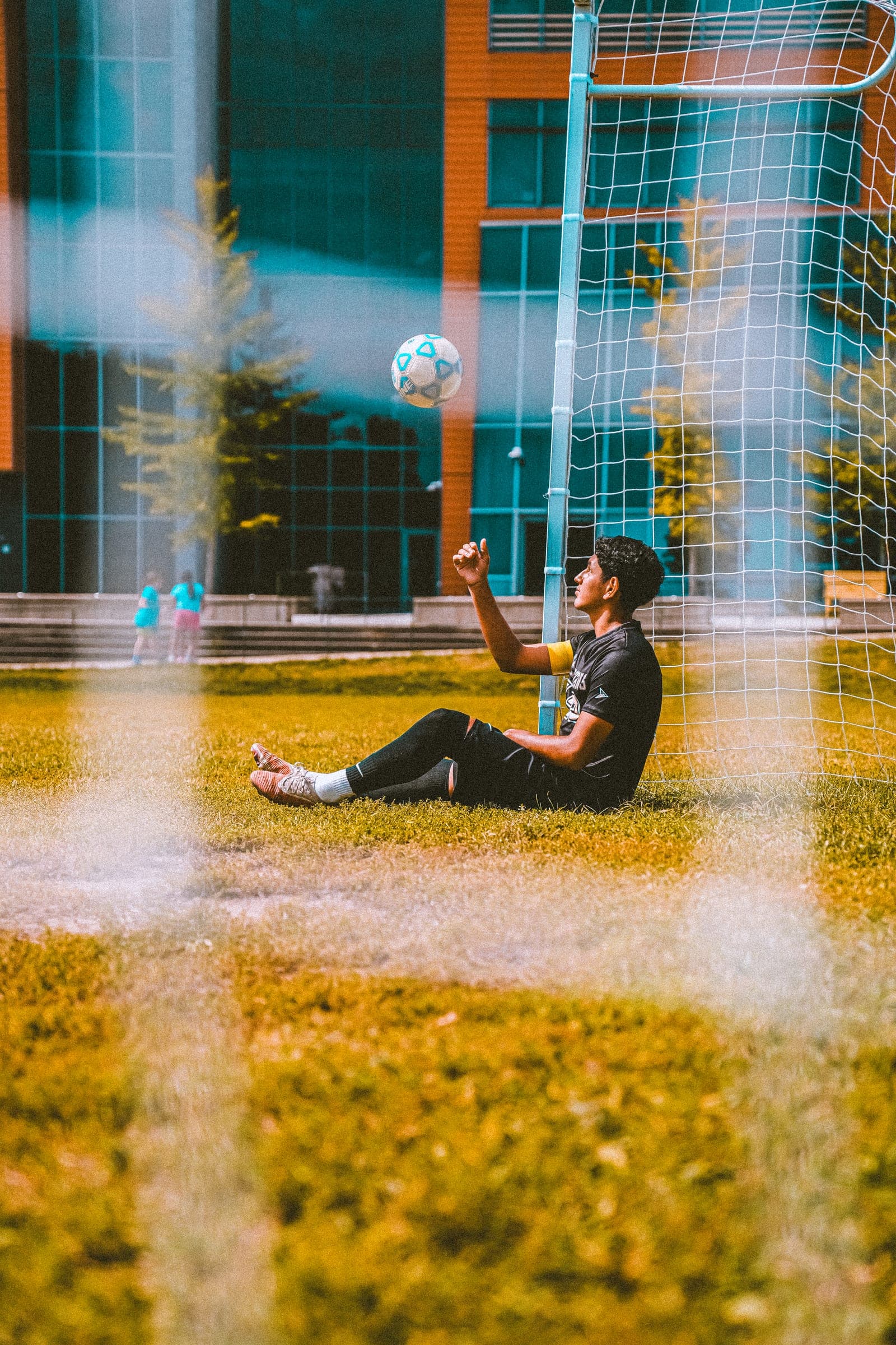 Player juggling the ball, framed through the goal net