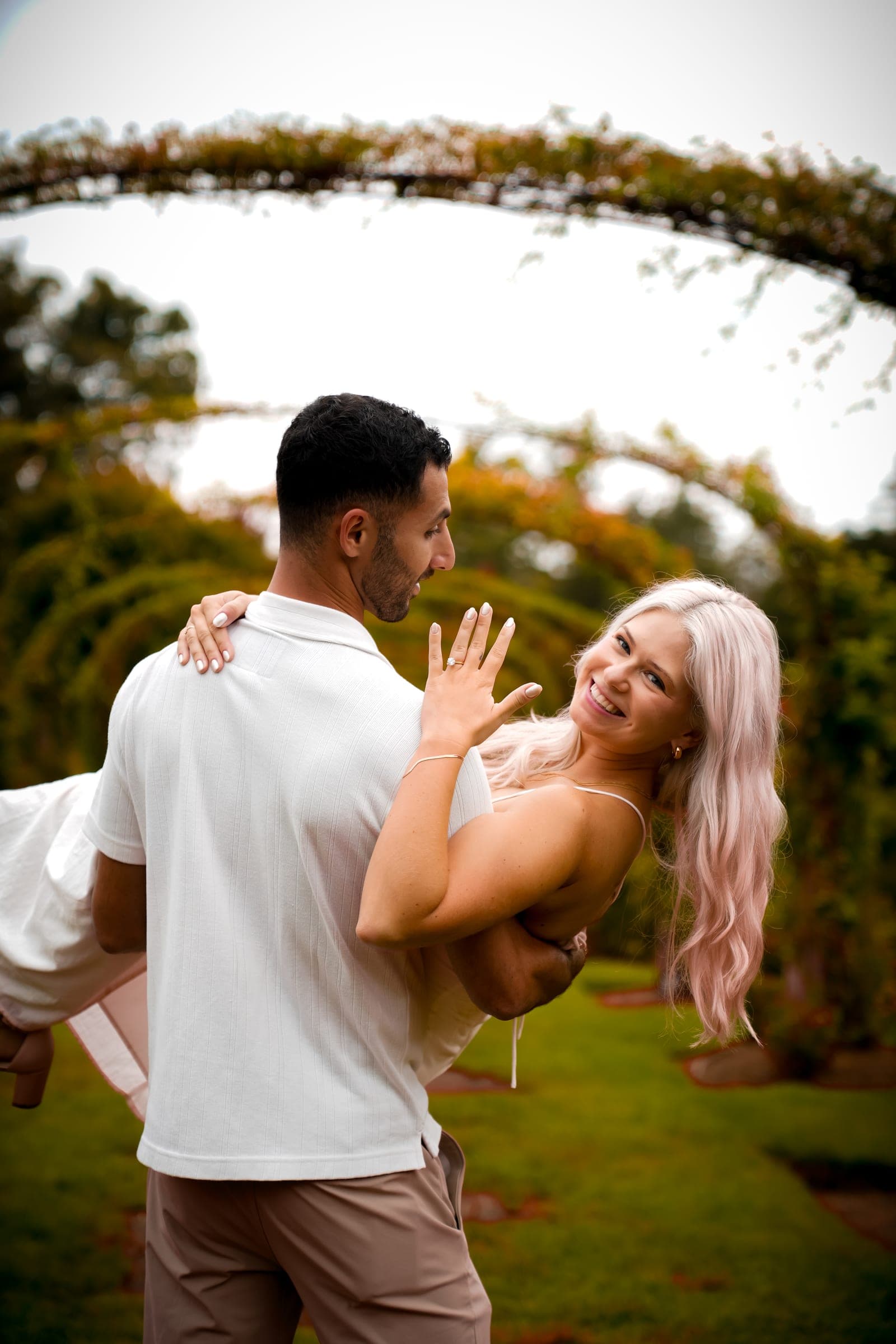 Couple laughing beneath a garden arch